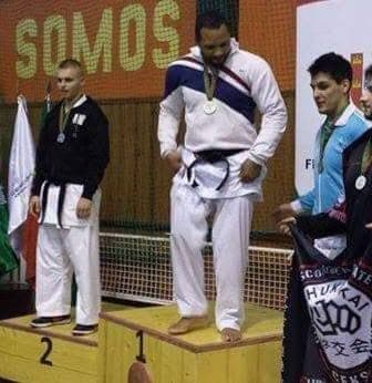 Trainer watches woman exercise on gym floor.